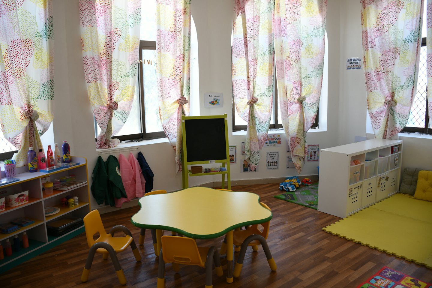 Children's classroom with small yellow table and art supplies.